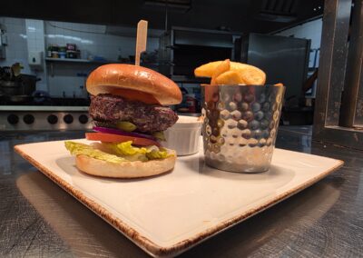 Beef Burger and Chips presented with the kitchen in the background