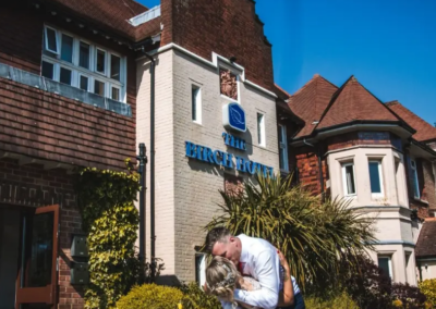 MArried couple kissing infront of The Birch Hotel