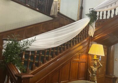 The BIrch Hotel Staircase dressed beautifully for a wedding with white drapes and green foliage